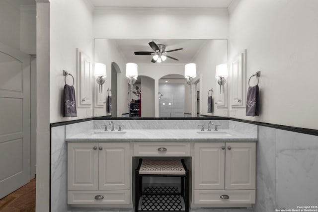 bathroom with ceiling fan, crown molding, tile walls, and vanity