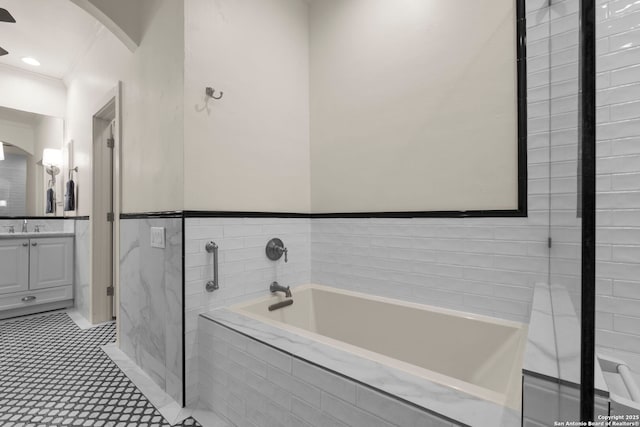 bathroom with vanity, tiled bath, and crown molding