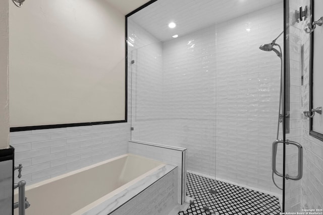 bathroom featuring separate shower and tub