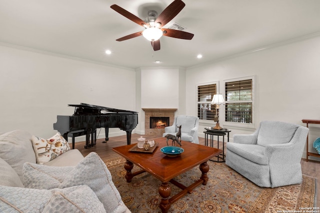 living room with hardwood / wood-style flooring, ceiling fan, and crown molding