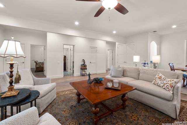 living room with ceiling fan, dark hardwood / wood-style flooring, and ornamental molding