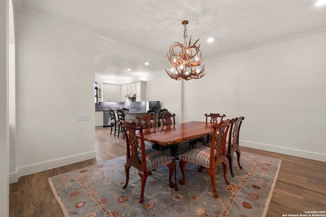 dining area featuring dark hardwood / wood-style flooring, a chandelier, and ornamental molding