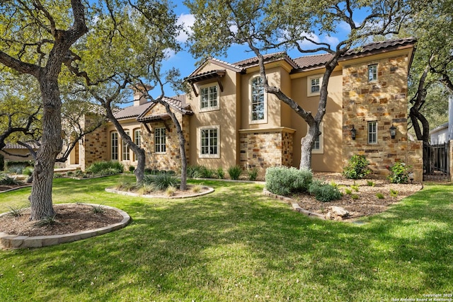 mediterranean / spanish-style house with stone siding, a tiled roof, a front lawn, and stucco siding