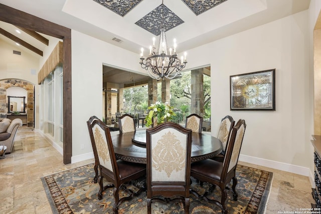 dining room with arched walkways, baseboards, stone tile floors, and an inviting chandelier