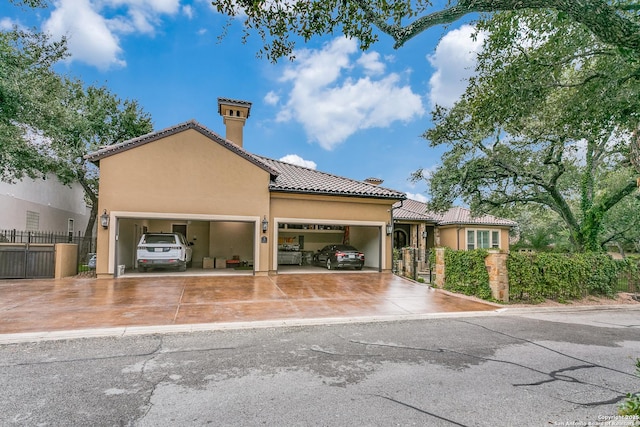 view of front facade with stucco siding, concrete driveway, fence, a garage, and a tiled roof