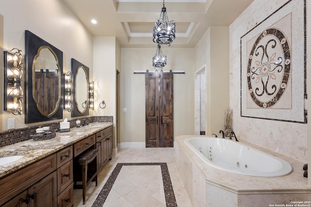 bathroom with double vanity, baseboards, a raised ceiling, a whirlpool tub, and a sink