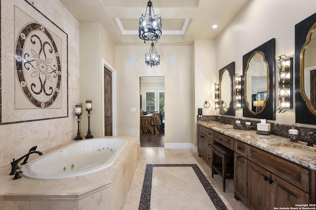 full bathroom featuring baseboards, ensuite bath, a whirlpool tub, an inviting chandelier, and vanity