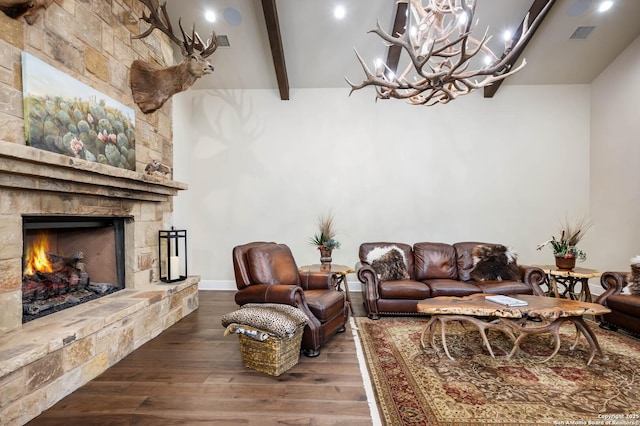 living area with dark wood-style floors, vaulted ceiling with beams, visible vents, and a fireplace