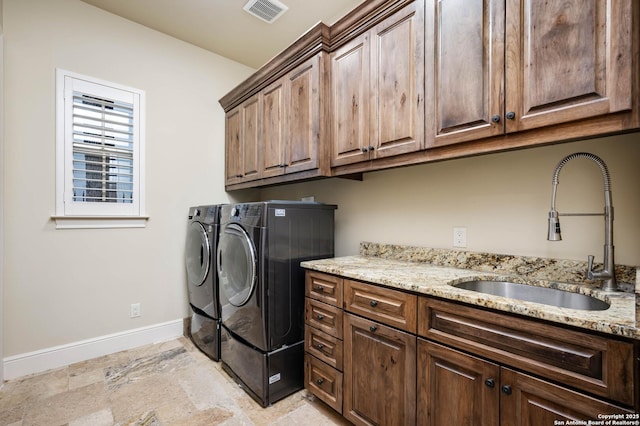 laundry room with cabinet space, baseboards, visible vents, washer and clothes dryer, and a sink