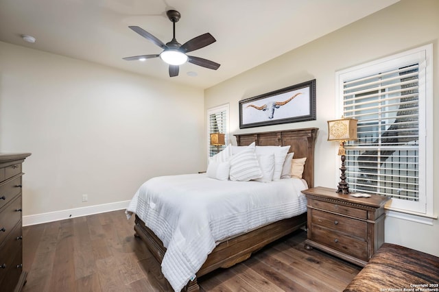 bedroom featuring a ceiling fan, dark wood finished floors, and baseboards