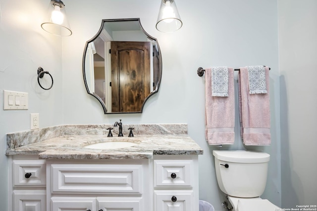 half bathroom featuring toilet and vanity