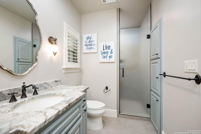 bathroom featuring toilet, a shower stall, vanity, tile patterned flooring, and baseboards