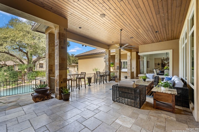 view of patio with a bar, outdoor dining area, outdoor lounge area, and a ceiling fan