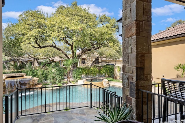 balcony with an in ground hot tub and a patio