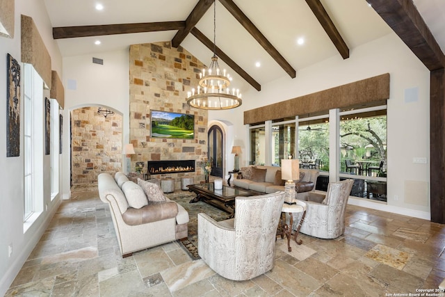 living room with arched walkways, stone tile floors, visible vents, a large fireplace, and high vaulted ceiling