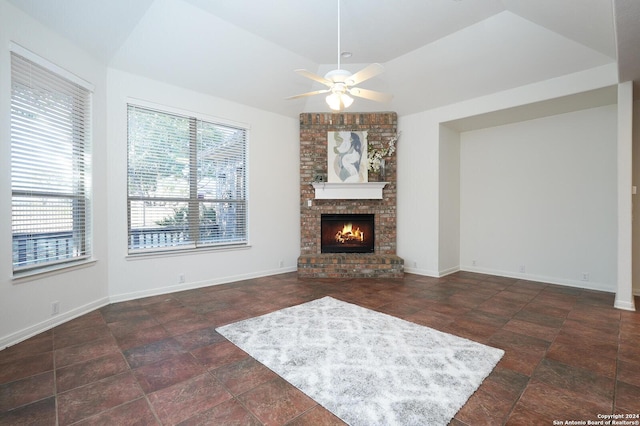 unfurnished living room with ceiling fan, a fireplace, and vaulted ceiling