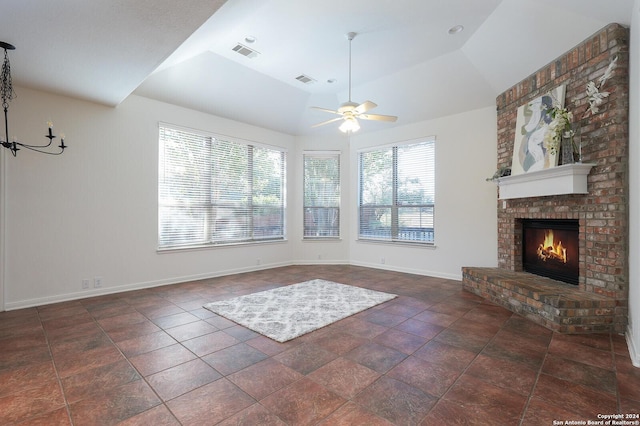 unfurnished living room featuring ceiling fan, a fireplace, dark tile patterned floors, and lofted ceiling