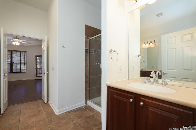 bathroom featuring tile patterned flooring, ceiling fan, a shower with shower door, and vanity