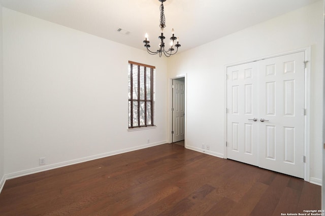 interior space featuring dark wood-type flooring and a notable chandelier