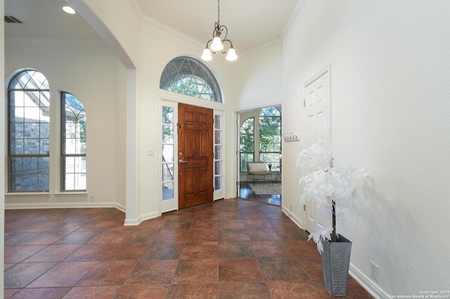 foyer featuring crown molding, plenty of natural light, and a high ceiling