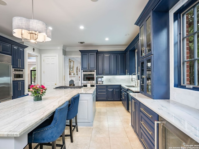 kitchen with built in fridge, a kitchen island, pendant lighting, and blue cabinets