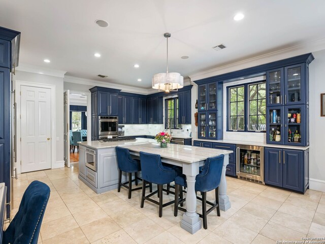 kitchen with stainless steel oven, a kitchen island, blue cabinetry, pendant lighting, and wine cooler