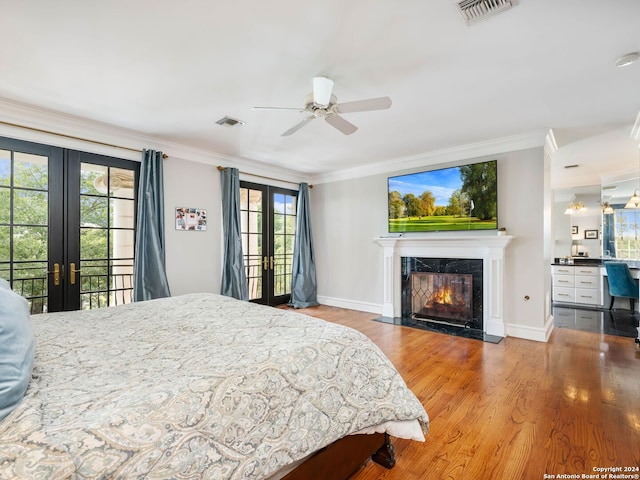 bedroom with ceiling fan, ornamental molding, a fireplace, and french doors