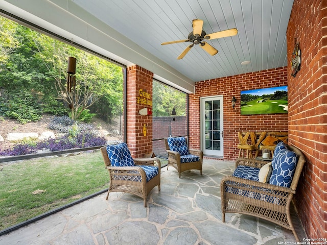 sunroom featuring ceiling fan and wood ceiling