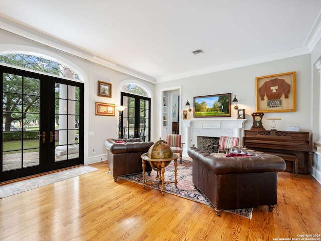 living room with a high end fireplace, french doors, light wood-type flooring, and ornamental molding