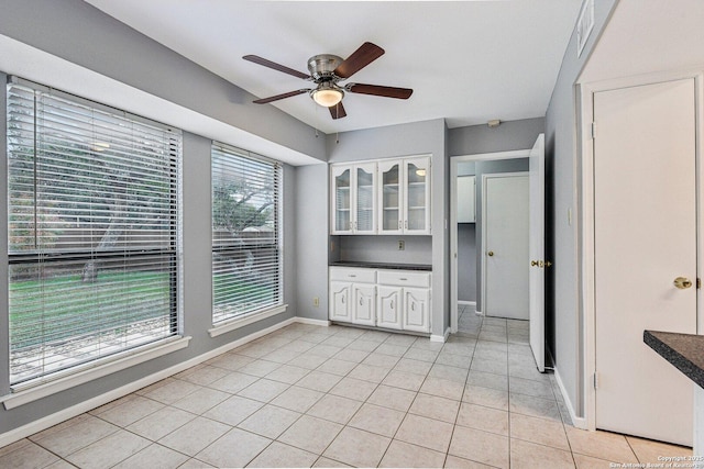 kitchen with white cabinets, ceiling fan, and light tile patterned flooring