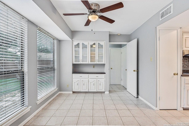 interior space with ceiling fan and light tile patterned floors