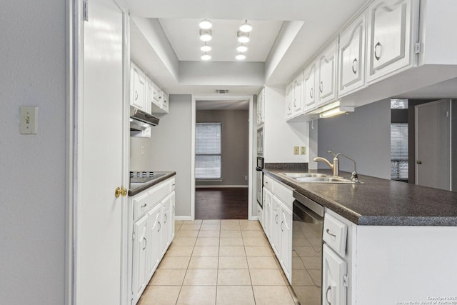 kitchen featuring white cabinets, sink, light tile patterned floors, appliances with stainless steel finishes, and a tray ceiling