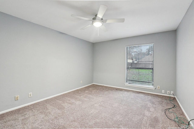 carpeted spare room with ceiling fan