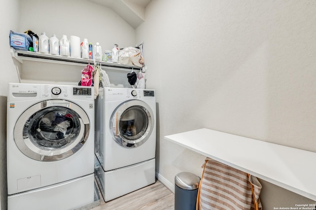 laundry room with light wood-type flooring and washing machine and dryer