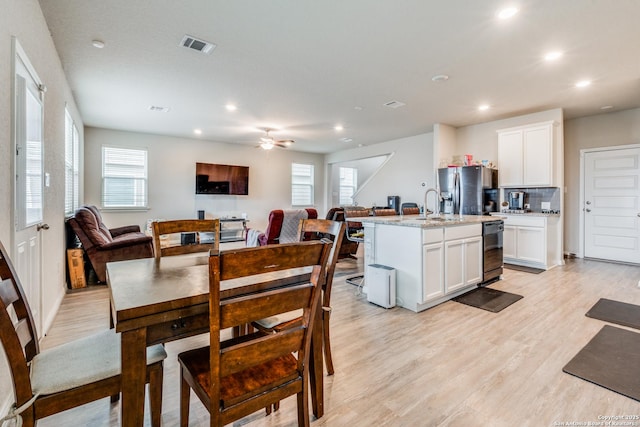 dining area featuring a healthy amount of sunlight, ceiling fan, and light hardwood / wood-style floors