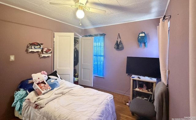 bedroom featuring ceiling fan, hardwood / wood-style floors, and ornamental molding