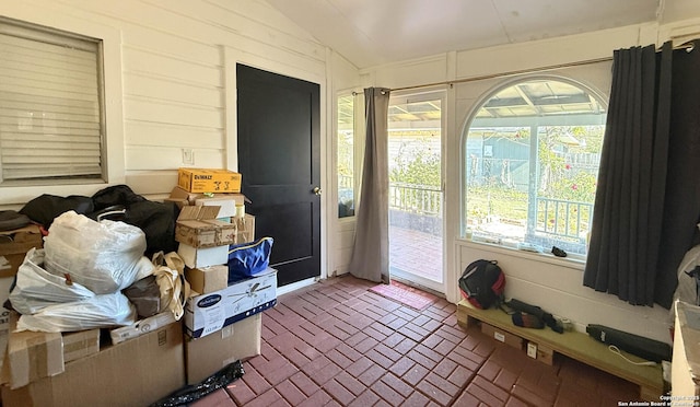 doorway to outside featuring vaulted ceiling