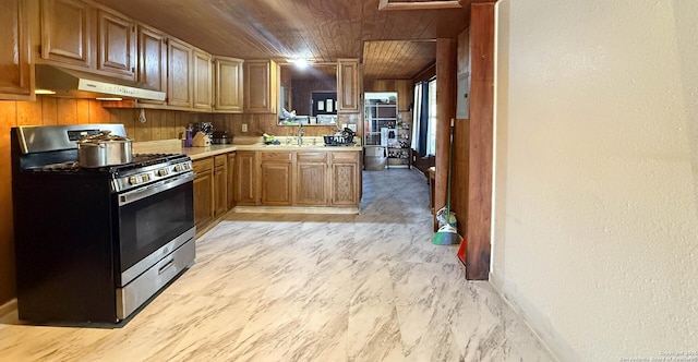 kitchen with stainless steel gas range and wood ceiling