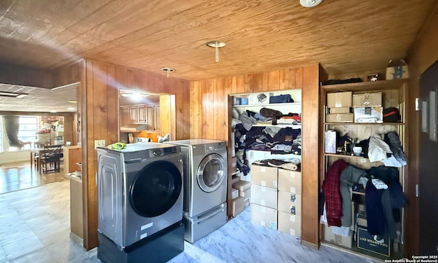 clothes washing area featuring wood walls, wood ceiling, and separate washer and dryer