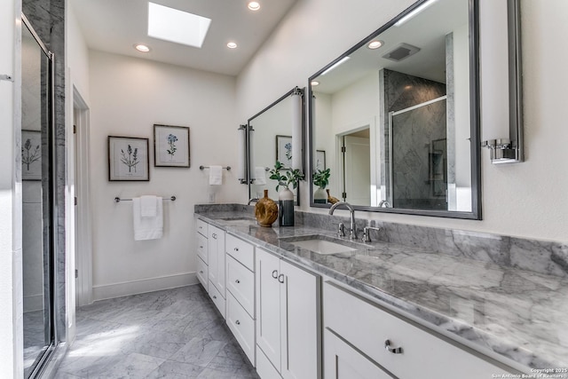 bathroom featuring vanity, a skylight, and a shower with shower door