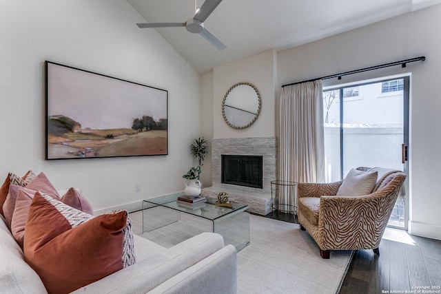 living room featuring a fireplace, hardwood / wood-style floors, vaulted ceiling, and ceiling fan