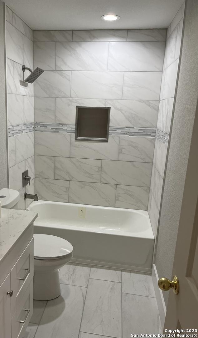 full bathroom with vanity, toilet, and tiled shower / bath