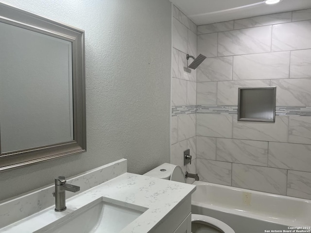 full bathroom with toilet, vanity, and tiled shower / bath