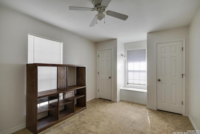 interior space with ceiling fan and multiple windows