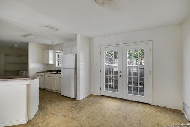 kitchen with french doors, white cabinets, white appliances, and sink