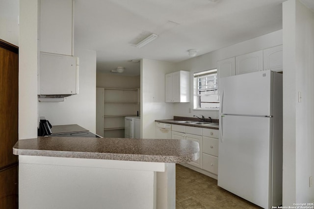 kitchen featuring white appliances, sink, white cabinetry, washer / dryer, and kitchen peninsula