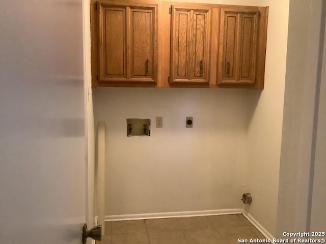 clothes washing area featuring cabinets, hookup for a washing machine, dark tile patterned flooring, and electric dryer hookup