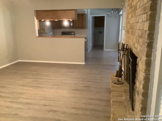 unfurnished living room with hardwood / wood-style flooring, a fireplace, and a notable chandelier