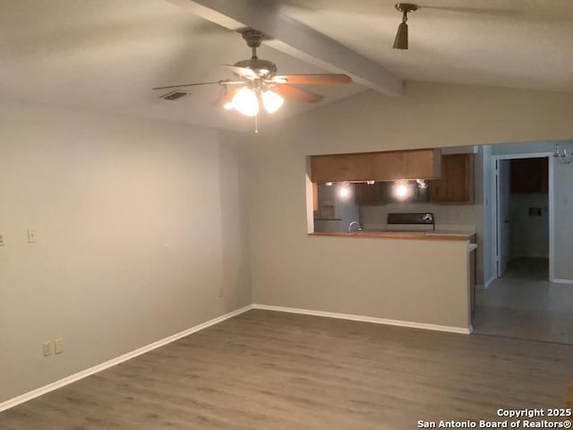 interior space with vaulted ceiling with beams, ceiling fan, and dark hardwood / wood-style flooring