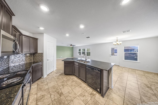 kitchen featuring a kitchen island with sink, ceiling fan with notable chandelier, sink, appliances with stainless steel finishes, and tasteful backsplash